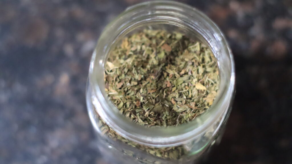 Dried peppermint leaves stored in a mason jar. 